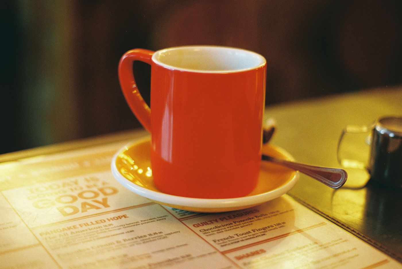 A cup of coffee on a diner counter beside a breakfast menu